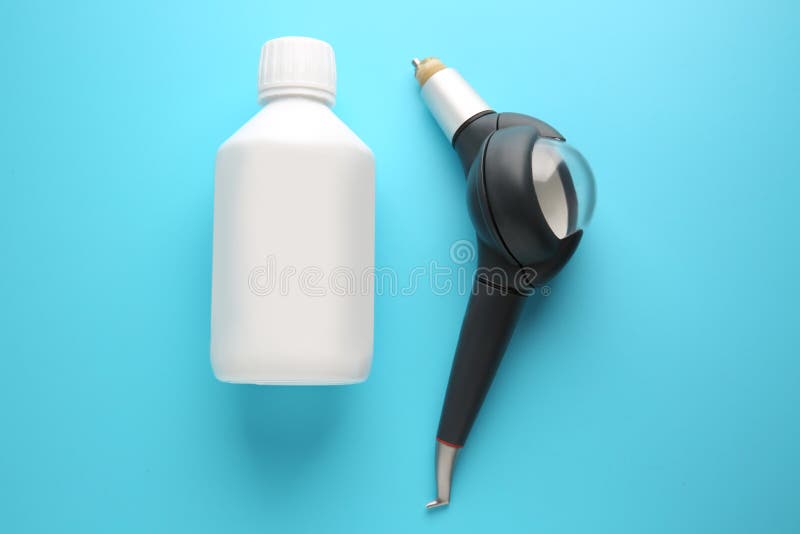 Air flow device and bottle of powder for removal treatments on color background royalty free stock photo