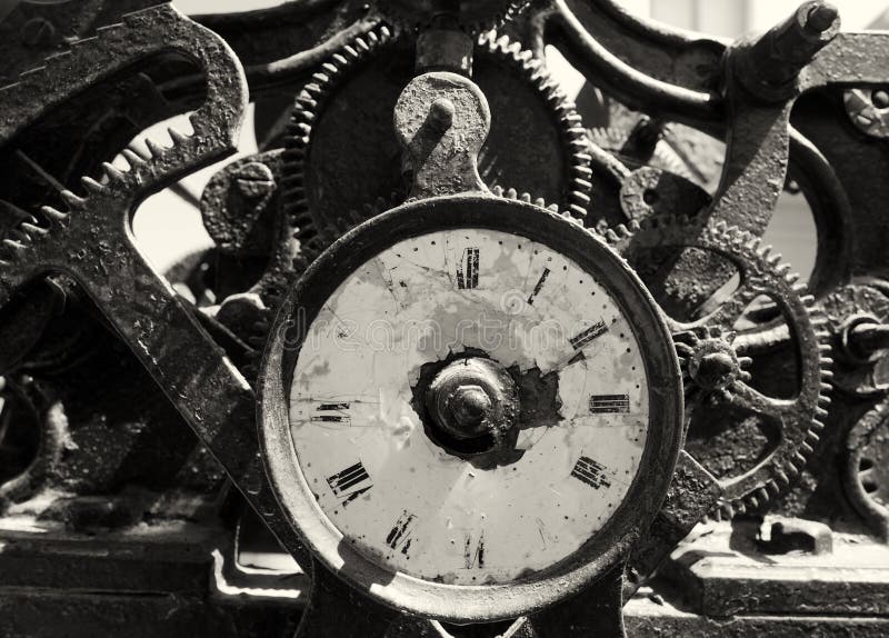 Ancient rusty broken iron clock with weathered face and exposed complex mechanism of cogs and gears. An ancient rusty broken iron clock with weathered face and royalty free stock photography