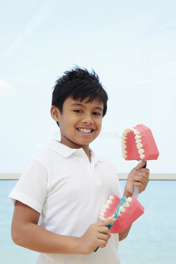 Boy showing the correct way to brush teeth. Conceptual image.  stock photography