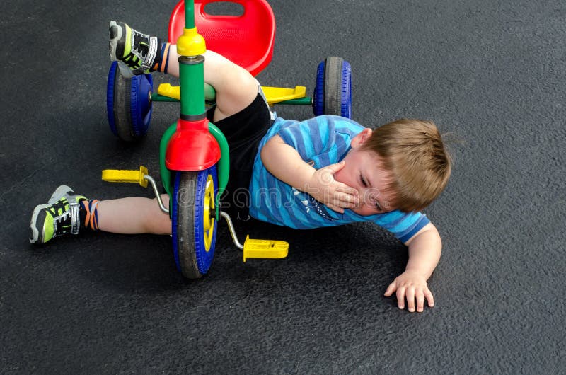Child falls off tricycle royalty free stock photos