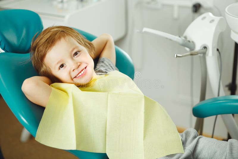 Child in good mood sitting on chair and without fear waiting dentist. Young boy is going to treat teeth. caries royalty free stock photos