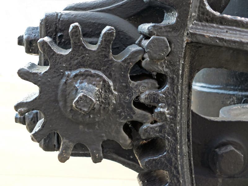 Close up of old worn black painted large cog wheels with gear teeth on obsolete industrial machinery. A close up of old worn black painted large cog wheels with royalty free stock image