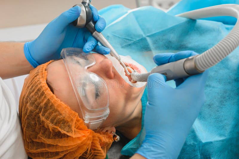 Closeup of dentist young woman removes tartar royalty free stock photos