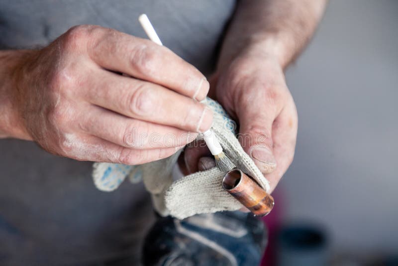 Closeup worker plumber master cleaning copper pipes with professional brush. Concept installation, changing pipeline, solder flux. Paste, professional repair royalty free stock images