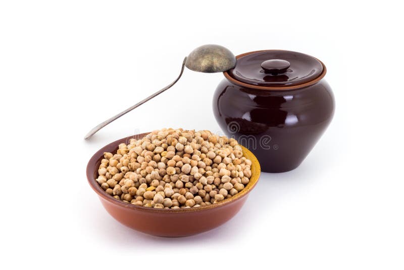 The composition of chick peas in a clay pial next to a clay pot and a copper spoon,. Still life of chick peas in ceramic pial, ceramic pot, old spoon , isolated royalty free stock image