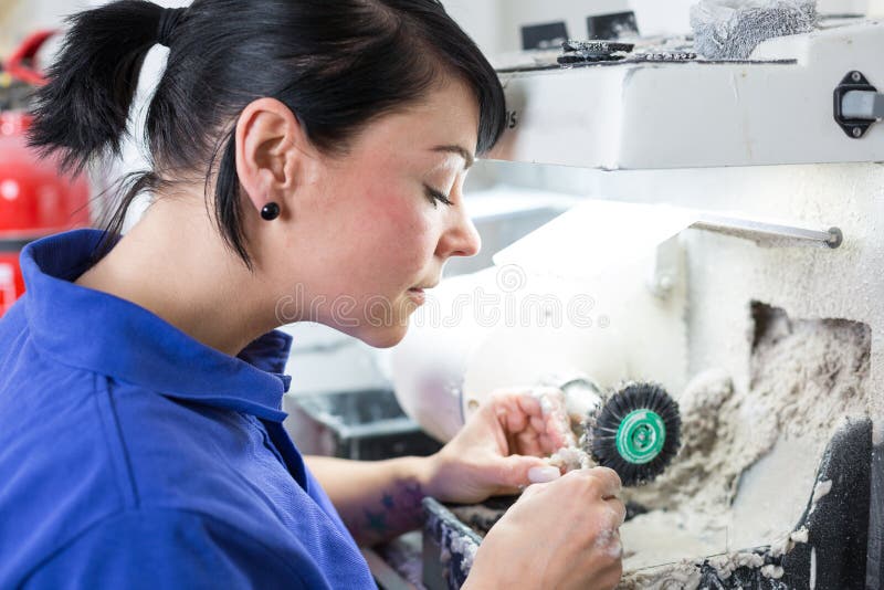 Dental technician polishing a prosthesis royalty free stock images