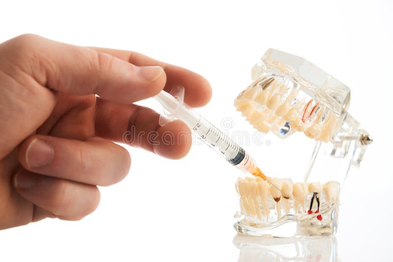 Dental anesthesia concept, close-up. Doctor dentist holding syringe, needle stabs into jaw between the teeth, pursuing dental anesthesia procedure. Dental stock images Dental anesthesia concept, close-up. Doctor dentist holding syringe, needle stabs into jaw between the teeth, pursuing dental anesthesia procedure. Dental stock images
