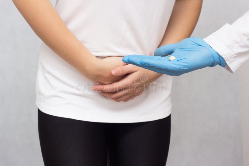 The doctor holds in his hand an anesthetic pill for menstruating a girl against pain, close-up, pain reliever. The doctor holds in his hand an anesthetic pill stock image
