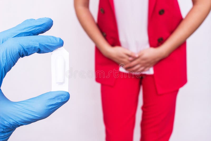 Doctor holds vaginal suppository suppository against the background of a girl who has pain and inflammation, urological infections. Vaginal microflora stock image