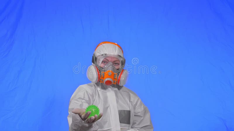 Doctor in respirator show a virus model. Slow motion. Woman wearing protect medical aerosol spray paint mask. Green ball stock photography
