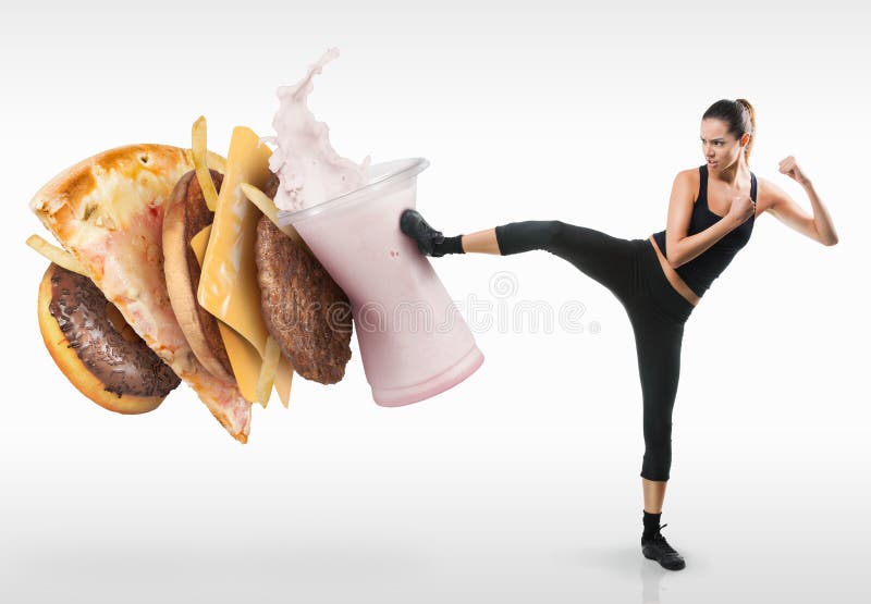 Fit young woman fighting off fast food royalty free stock photography