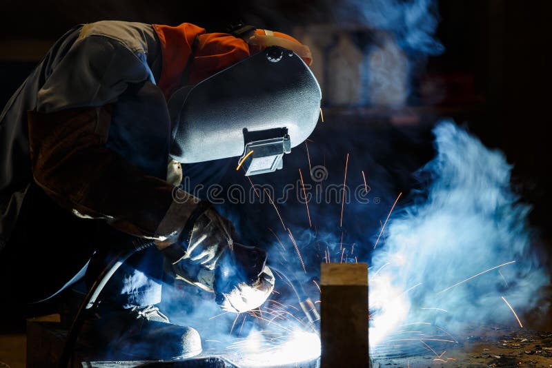 Flux cored wire arc welding process. Worker fabricate structure by flux cored wire arc welding process stock image
