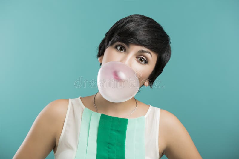Girl with a bubble gum. Portrait of a beautiful girl with a bubble gum on the mouth, against a blue background stock photography