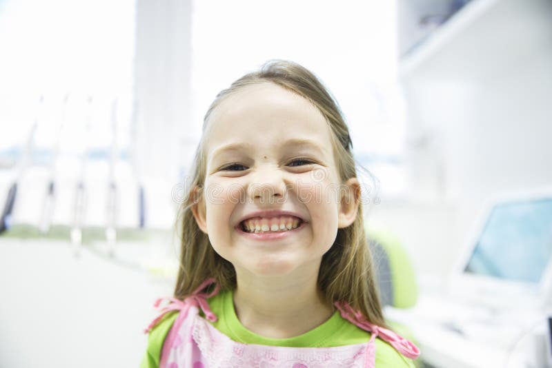 Girl showing her healthy milk teeth at dental office royalty free stock images