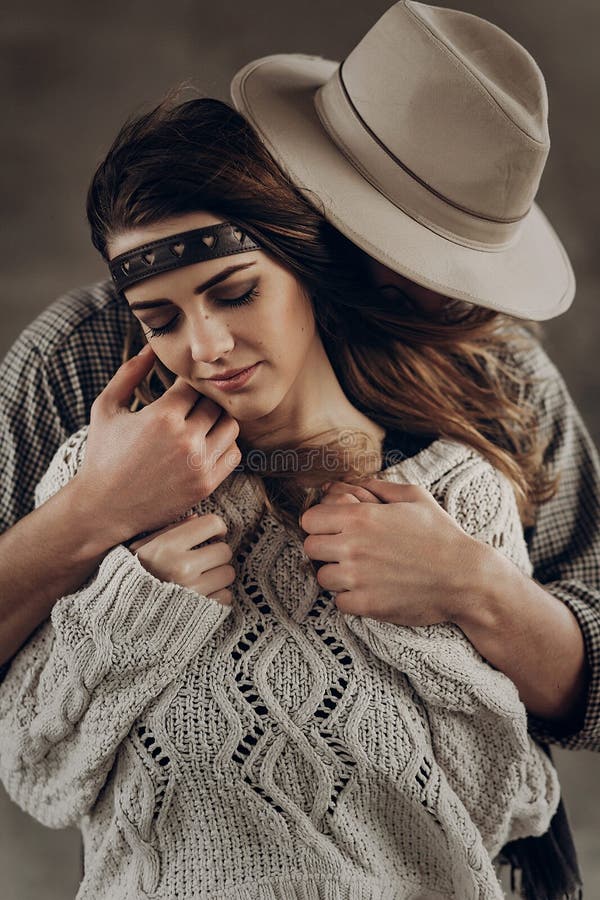 Handsome cowboy man in white hat touching cheek of beautiful boho gypsy woman with leather headband, face closeup portrait. Handsome cowboy men in white hat royalty free stock photos