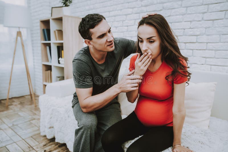 Husband and Pregnant Wife Have a Conflict. Woman Feeling a Toothache. Woman is a Young Brunette Pregnant Girl. Man is Support and Touching Her Wife. Woman is royalty free stock image