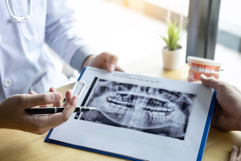 Image of doctor or dentist presenting with tooth x-ray film recommend patient in the treatment of dental and dentistry, working at royalty free stock images