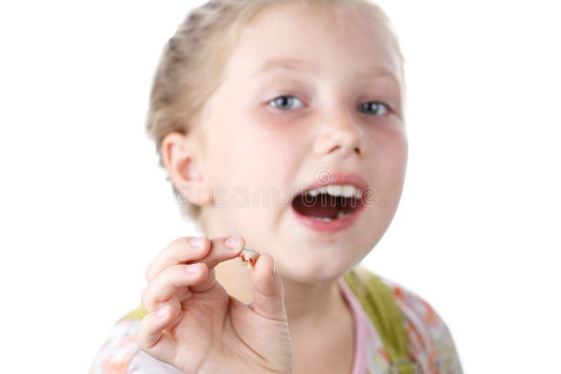 Little girl is holding in her hands her first torn tooth royalty free stock photos
