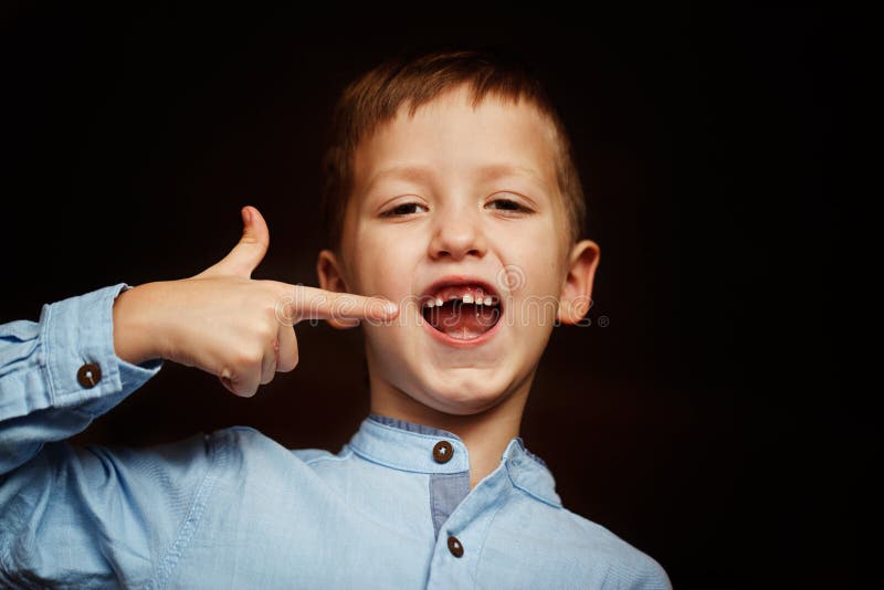 Little smiling child, boy hand showing his first milk or temporary teeth fall out. stock photos