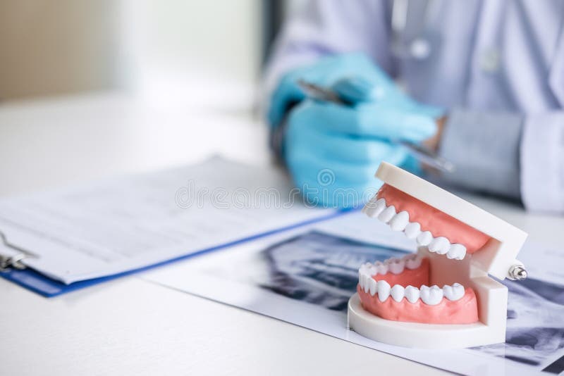 Male doctor or dentist working with patient tooth x-ray film, model and equipment used in the treatment and analysis teeth disease royalty free stock image