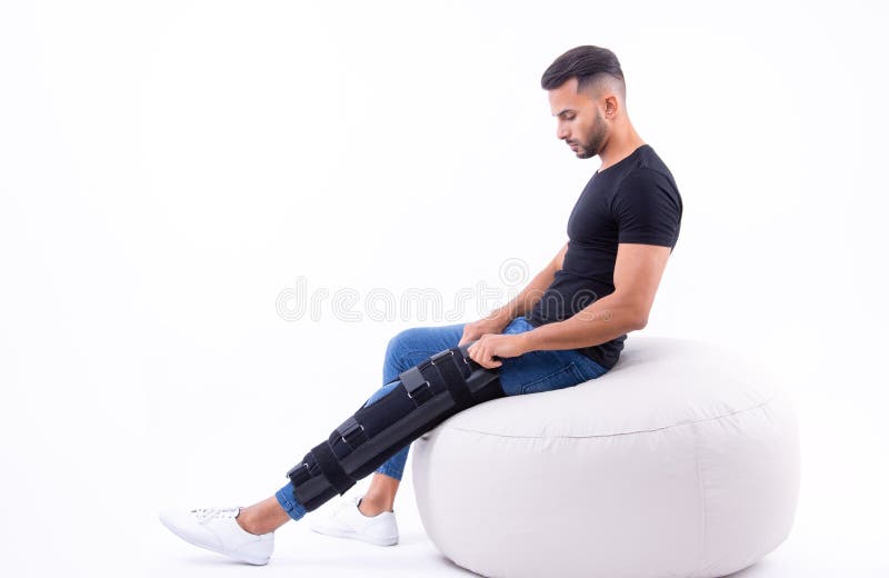 Man wearing supportive leg brace in studio. With white background stock photography
