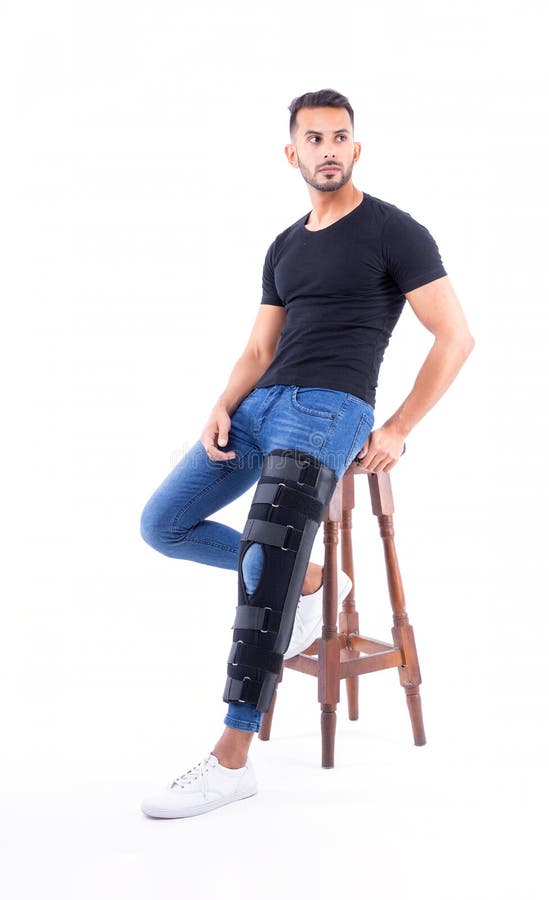 Man wearing supportive leg brace in studio. With white background stock photo