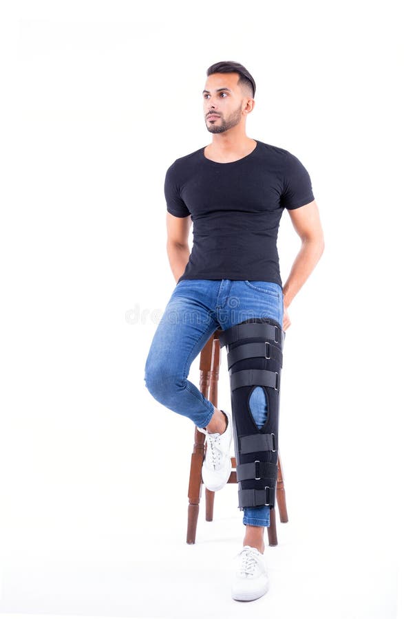 Man wearing supportive leg brace in studio. With white background royalty free stock images