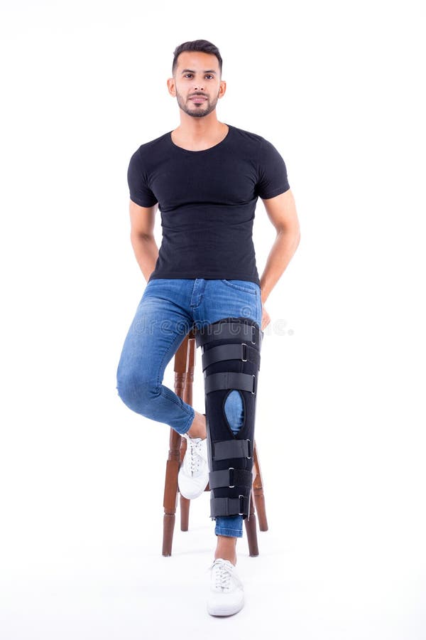 Man wearing supportive leg brace in studio. With white background royalty free stock image