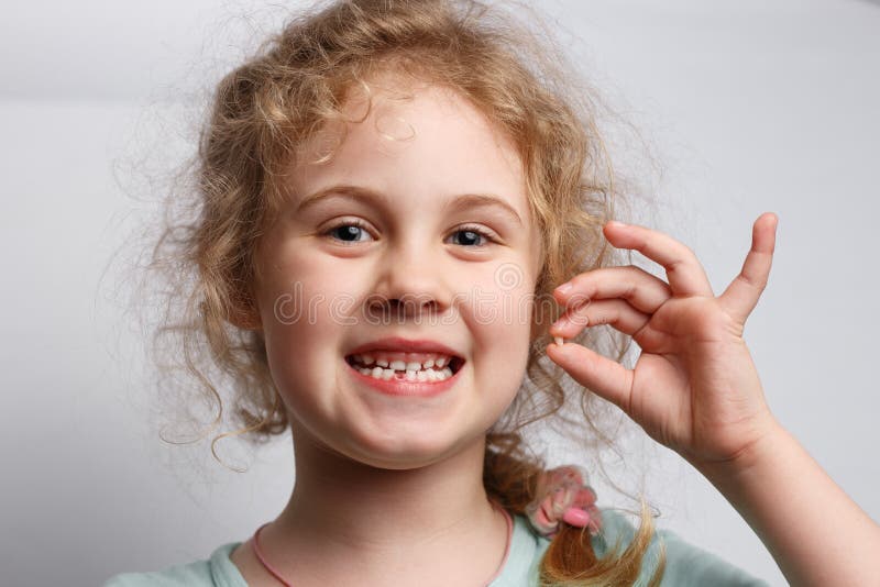 Portrait of cute six years girl losing her first milk tooth stock photography
