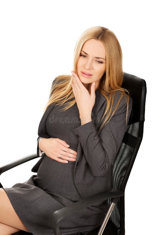 Pregnant woman suffering from tooth pain. Pregnant woman in the office suffering from tooth pain stock images