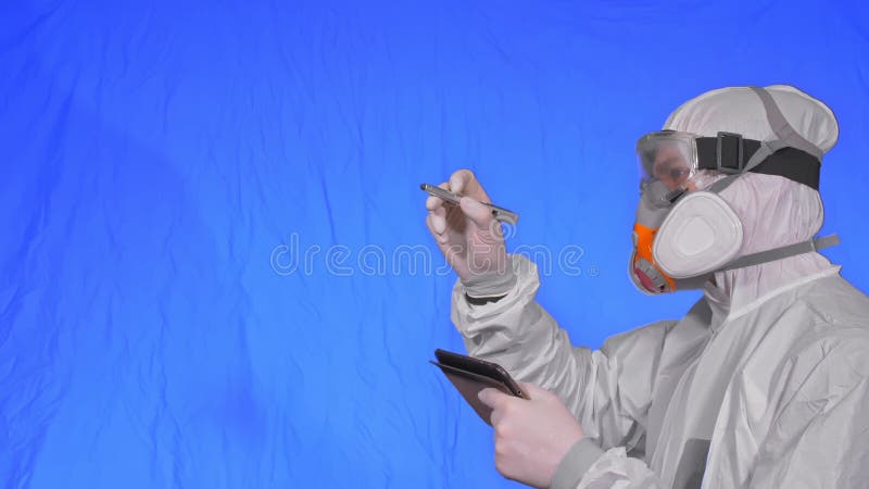 Scientist virologist in respirator makes write in an tablet computer with stylus. Man wearing protective medical mask. Concept health safety virus coronavirus royalty free stock image