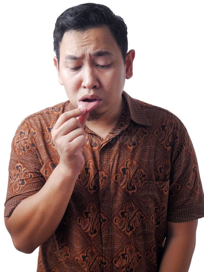 Sick Man Show His Inner Lip. Sick Asian man wearing batik shirt shows his inner lip, suffering from mouth ulcers, care, close, blemish, cavity, condition royalty free stock photo
