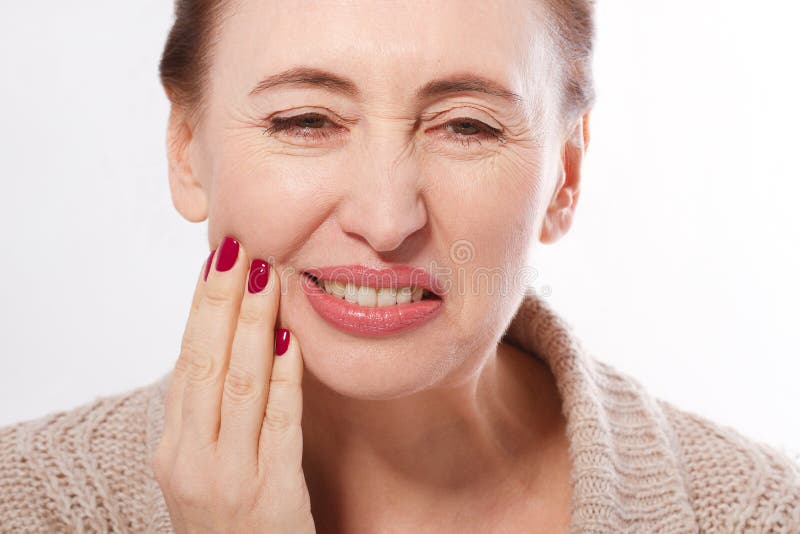 Tooth pain and dentistry. Macro face of middle age woman suffering about strong teeth pain, touching cheek by hand isolated on whi. Te. Painful toothache. Dental stock photos