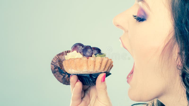 Woman face profile open mouth eating cake royalty free stock photography