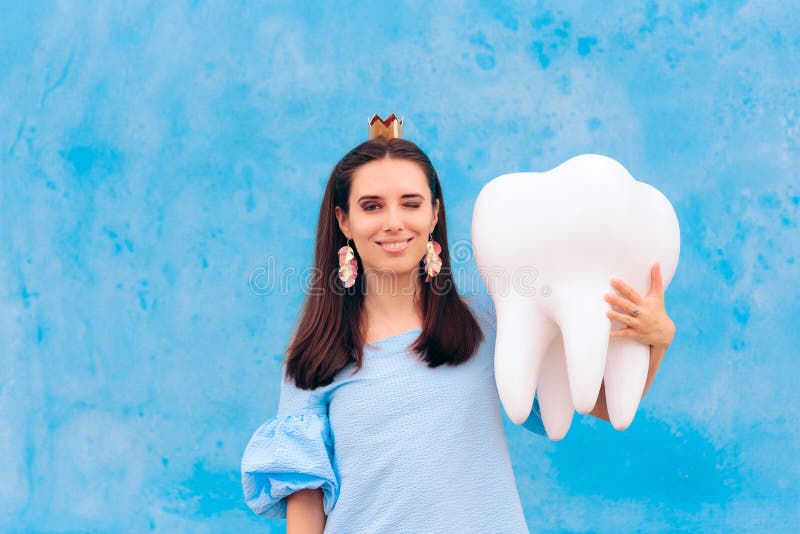 Woman in Tooth Fairy Costume Holding Big Molar. Funny princess holding an oversized fallen baby tooth stock photos