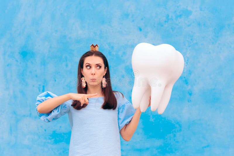 Woman in Tooth Fairy Costume Holding Big Molar. Funny princess holding an oversized fallen baby tooth stock image
