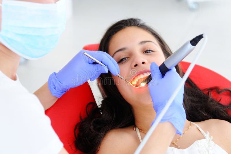 Young beautiful girl in dental office. Children`s dentist examines teeth to a child royalty free stock images