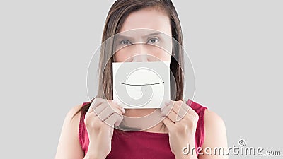 Bad breath or Halitosis. Asian woman in the red shirt holding a brown paper with the yellow teeth cartoon picture of his mouth against the gray background, Bad stock footage