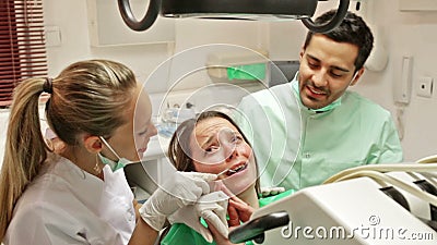 Dentist, assistant and scared patient. At surgery office stock video footage