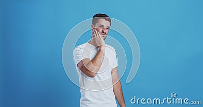 Young man suffering from acute dental pain. Tooth problem. Young man suffering from dental pain, blue studio background stock video